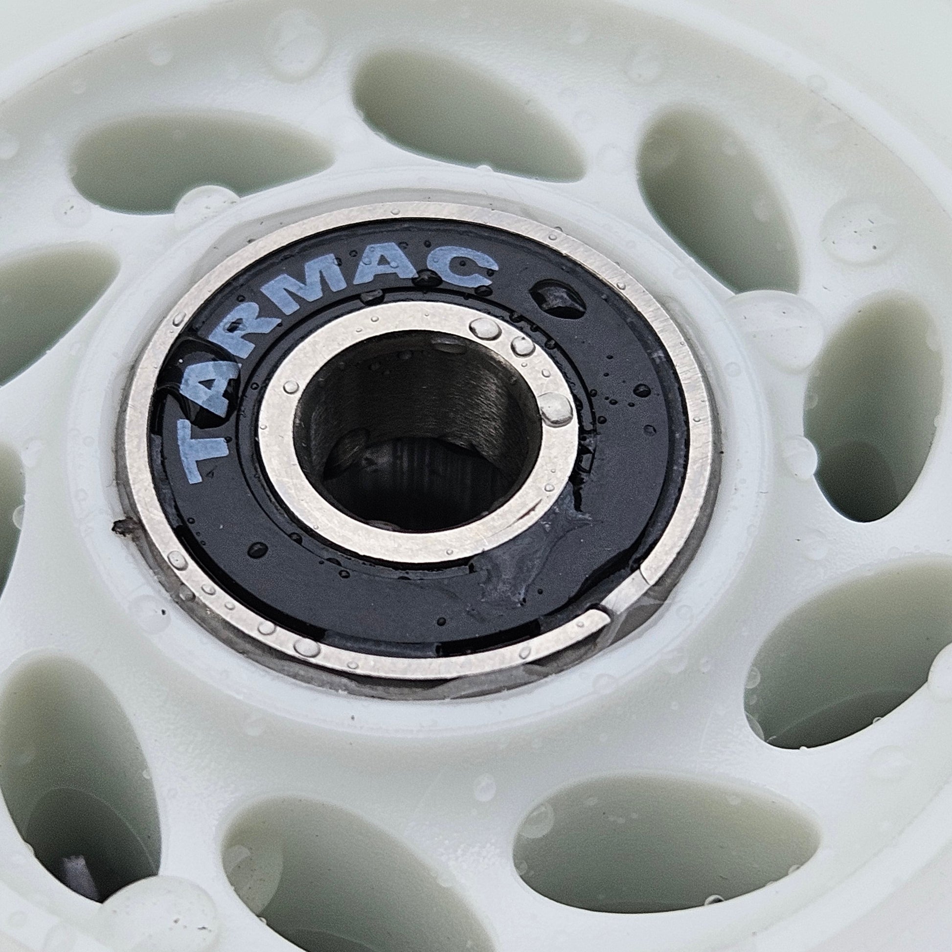 Close-up of a Tarmac skate wheel with a white rim and black center.